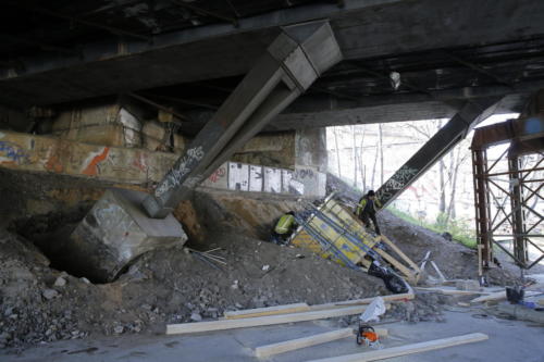 Sanace patek žel. mostu přes ulici Vršovická - patky se nejprve částečně obnažili a poté obetonováním zesílily.